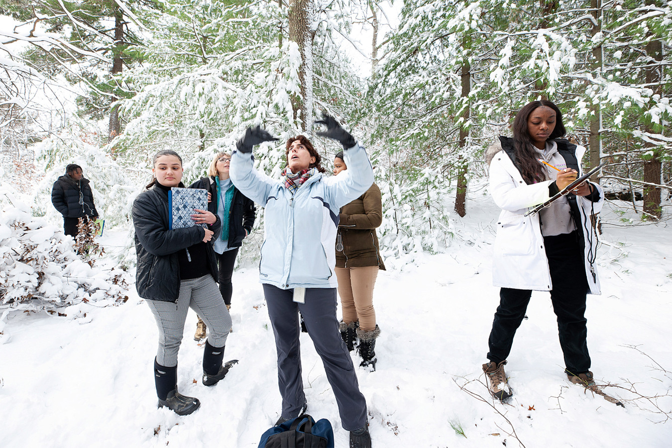 Ana Maria Caballero McGuire and students learning about trees in the snow