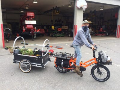 Horticulturist Scott Phillips leaving the equipment garage with cargo bike and trailer set up for weeding