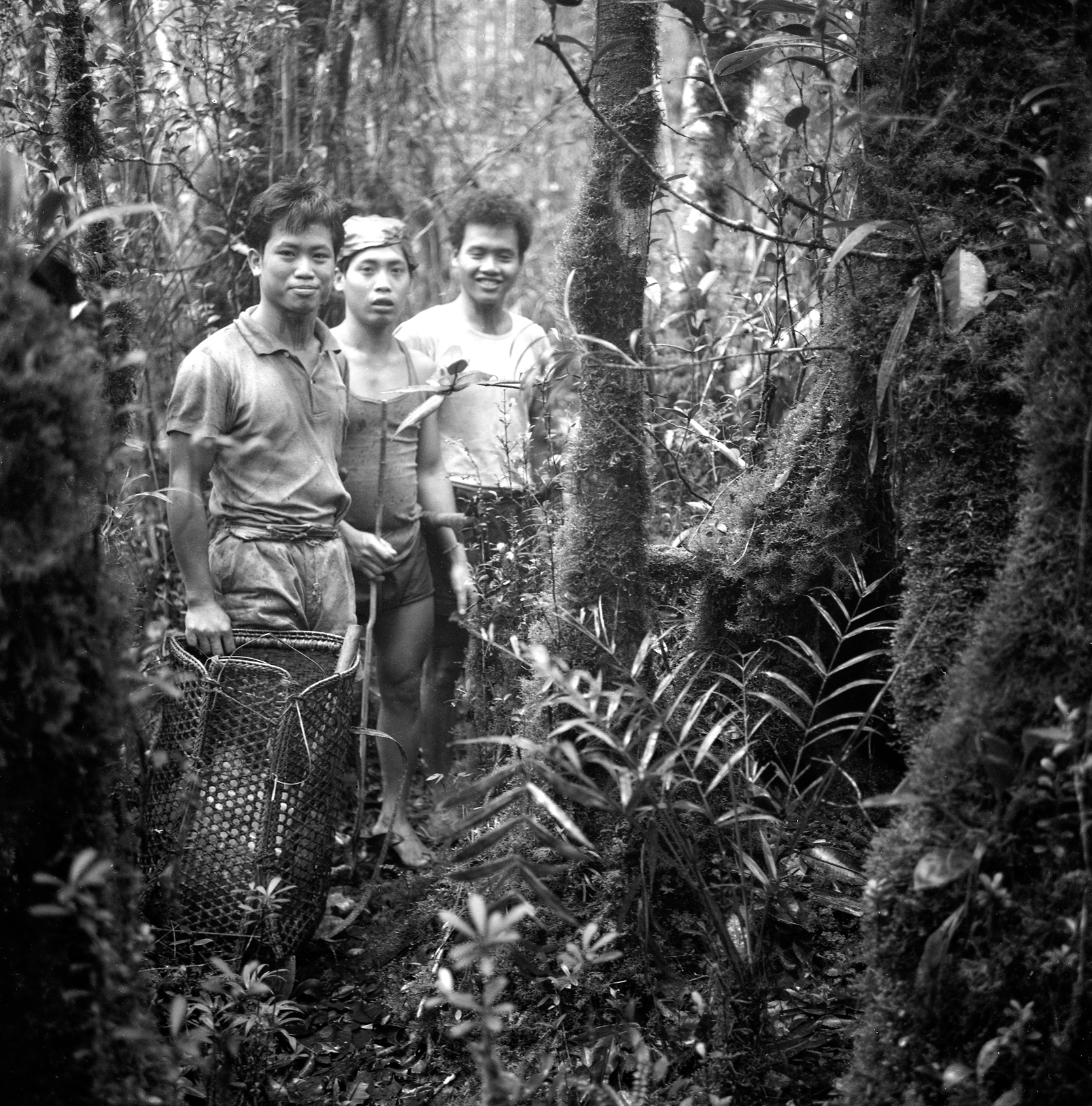 Three field assistants with supplies. The one in front holds a selabit.