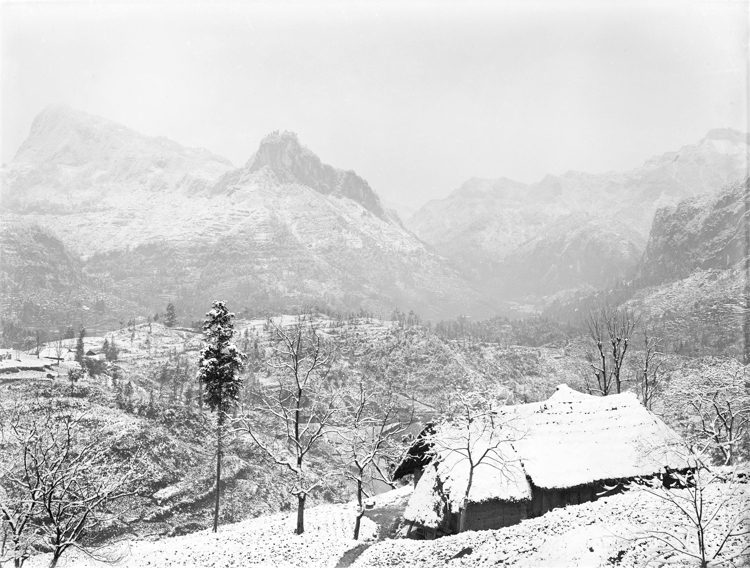 Snow on mountains with small house in foreground