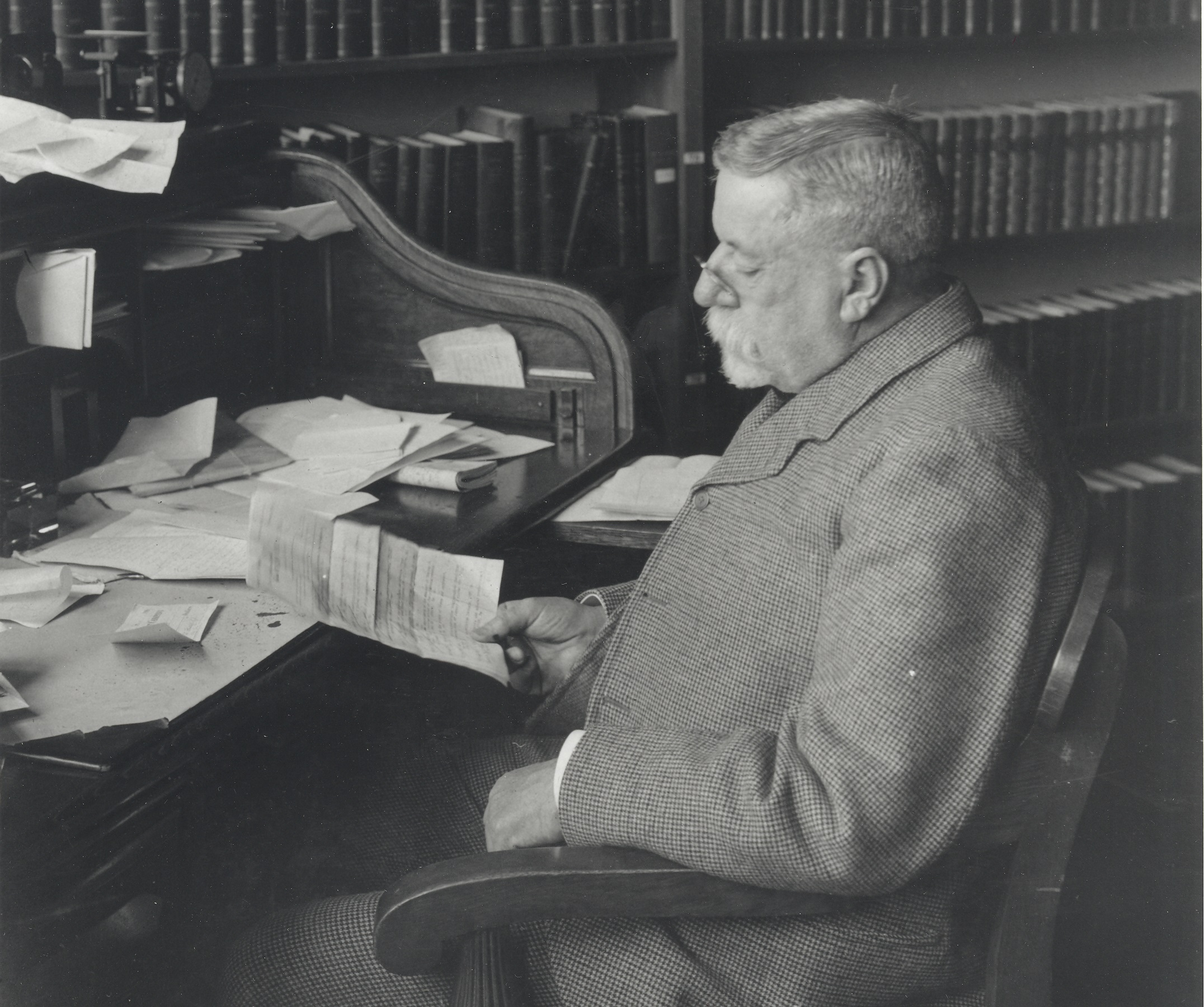 Charles Sargent seated at a desk in the library.