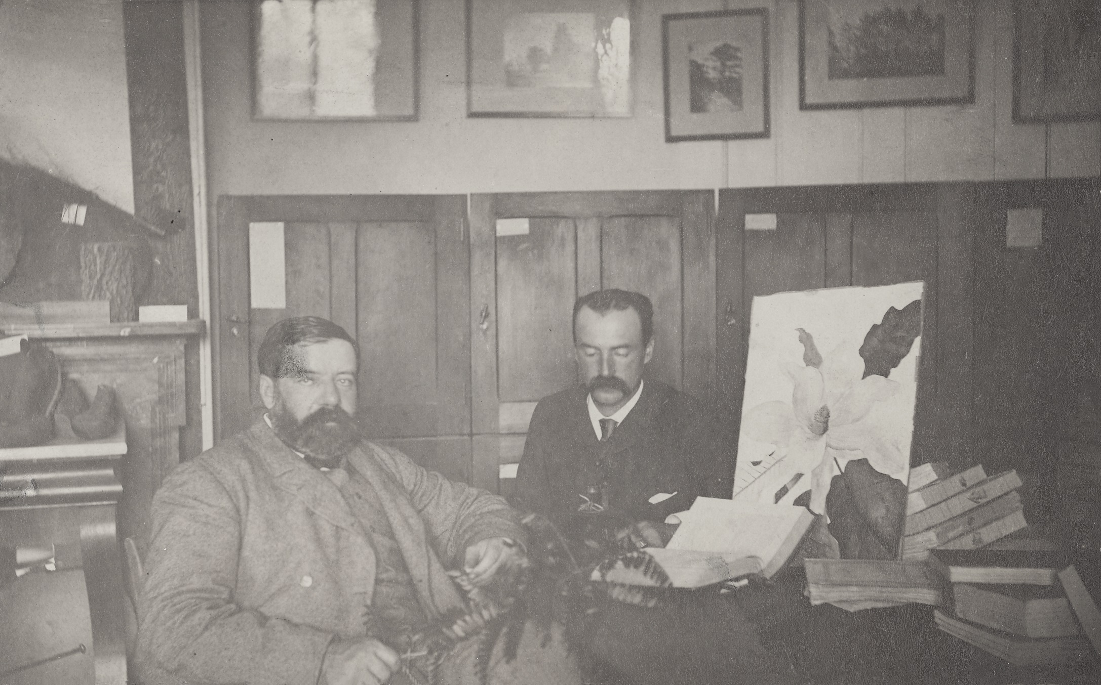 Charles S. Sargent and Charles E. Faxon seated in front of herbarium cases.