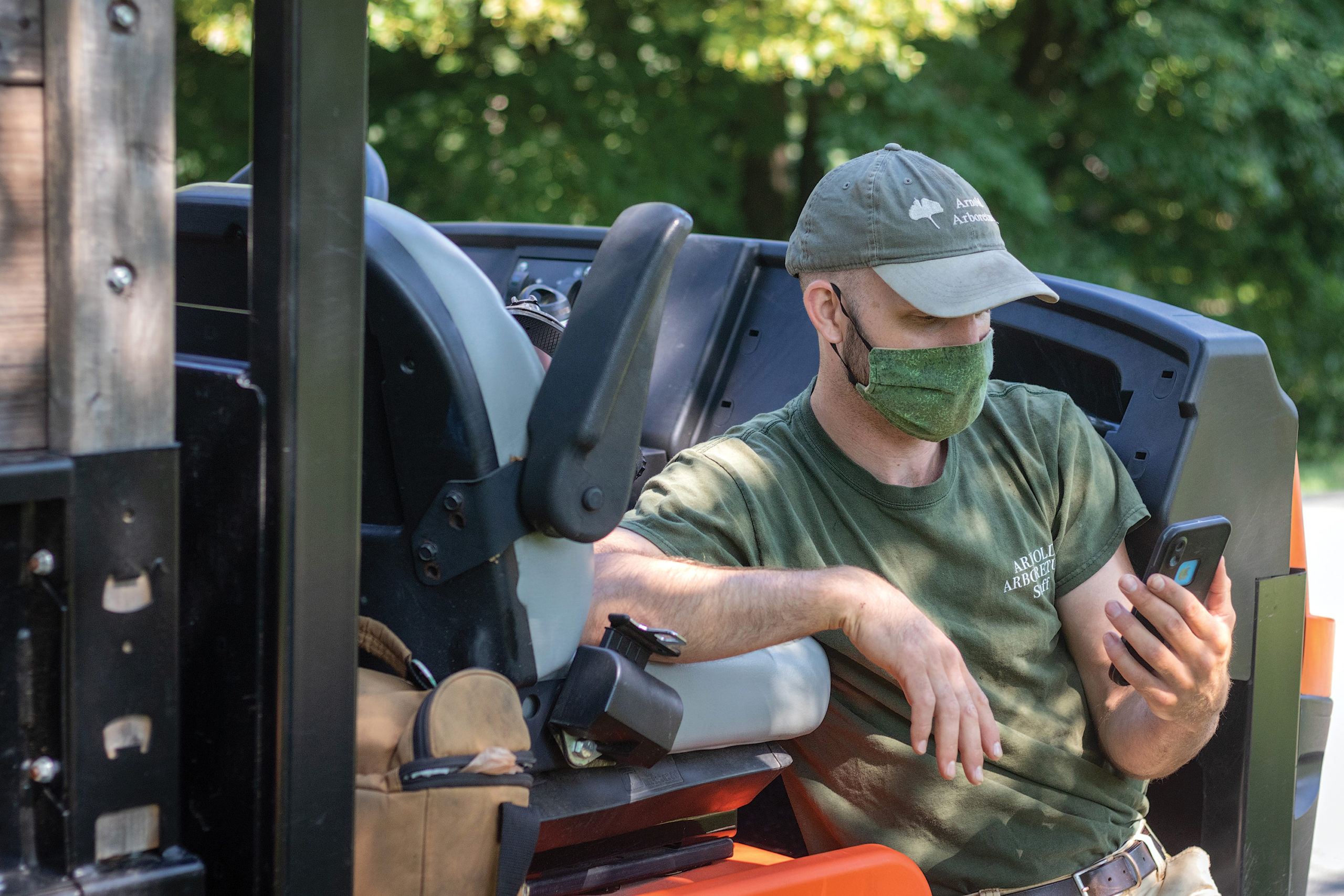 Horticulturist wearing mask and looking at phone