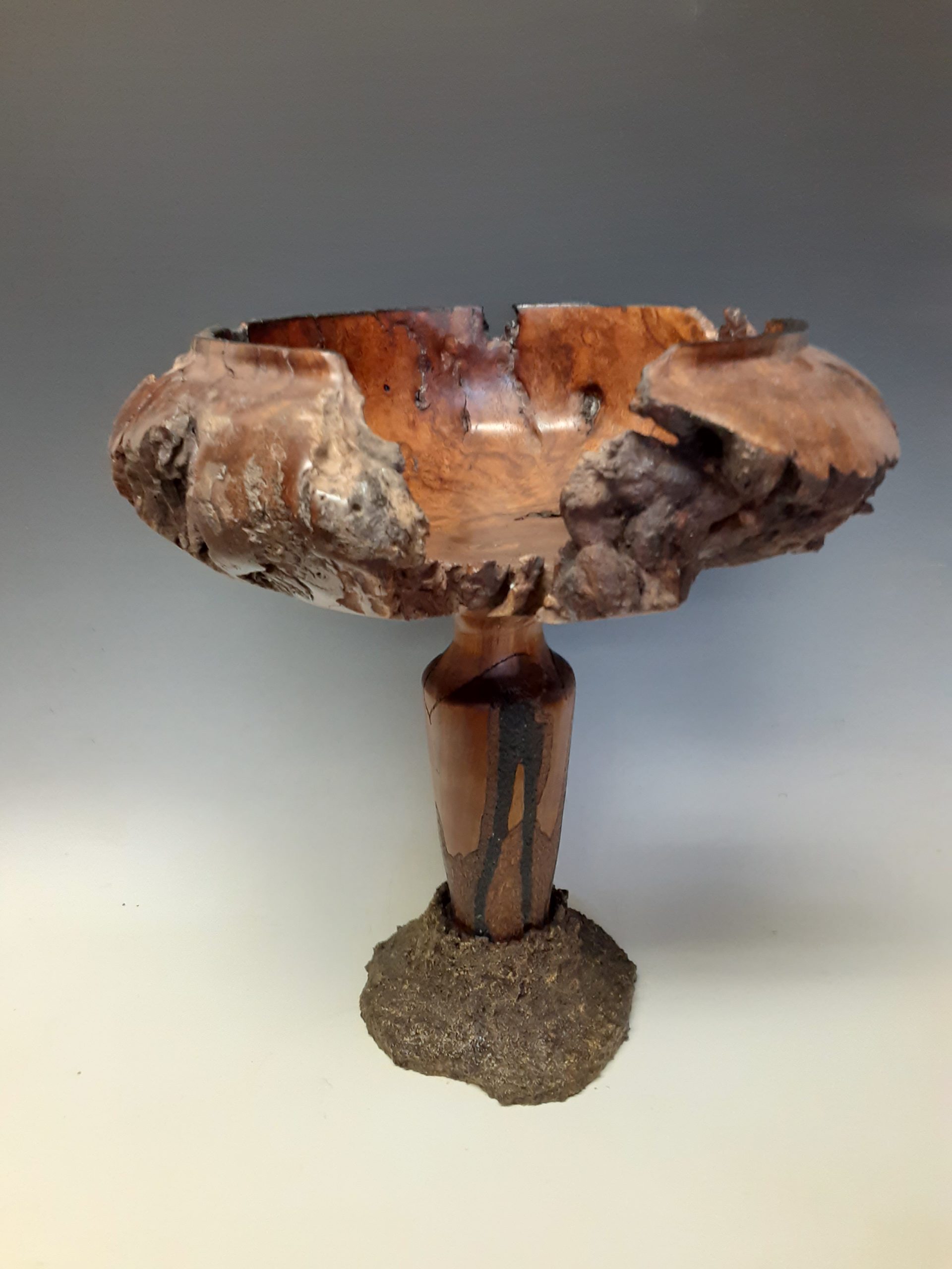 wooden pedistal with wood bowl on top