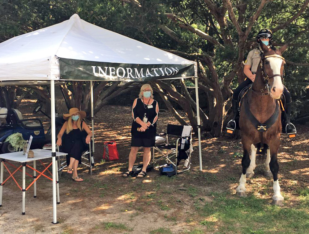 Two women under tent and ranger on horseback