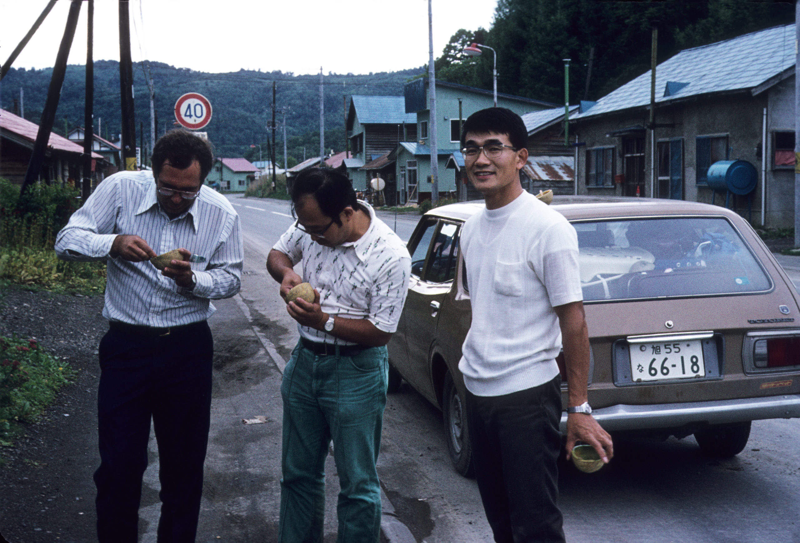 Richard Weaver, Katsuhiko Kondo, and Sato eating hybrid cantaloupe-honeydew melons by a roadside in Hokkaido. Photograph by Stephen Spongberg, September 9, 1977.