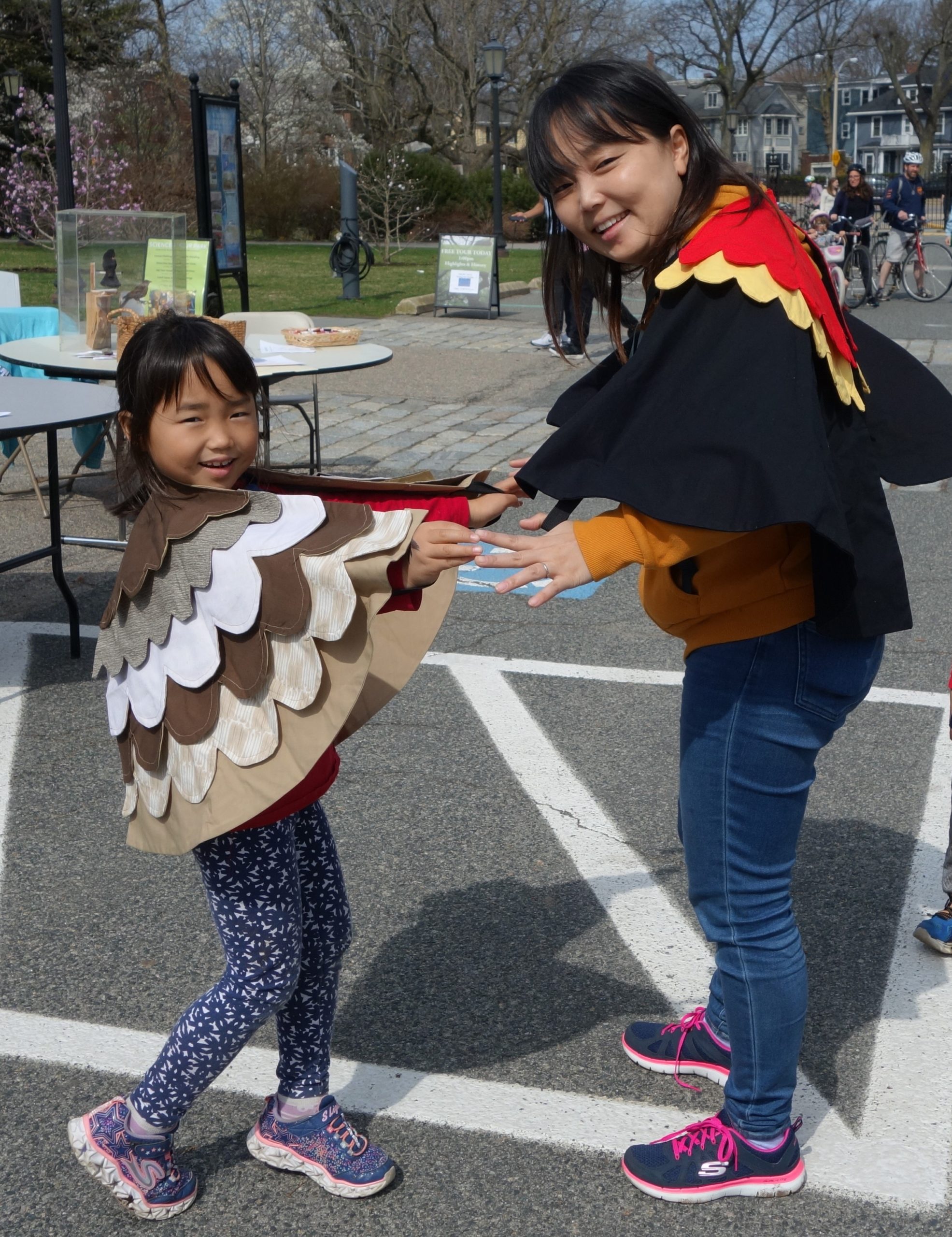 A mother and daughter wear redwing blackbird capes.