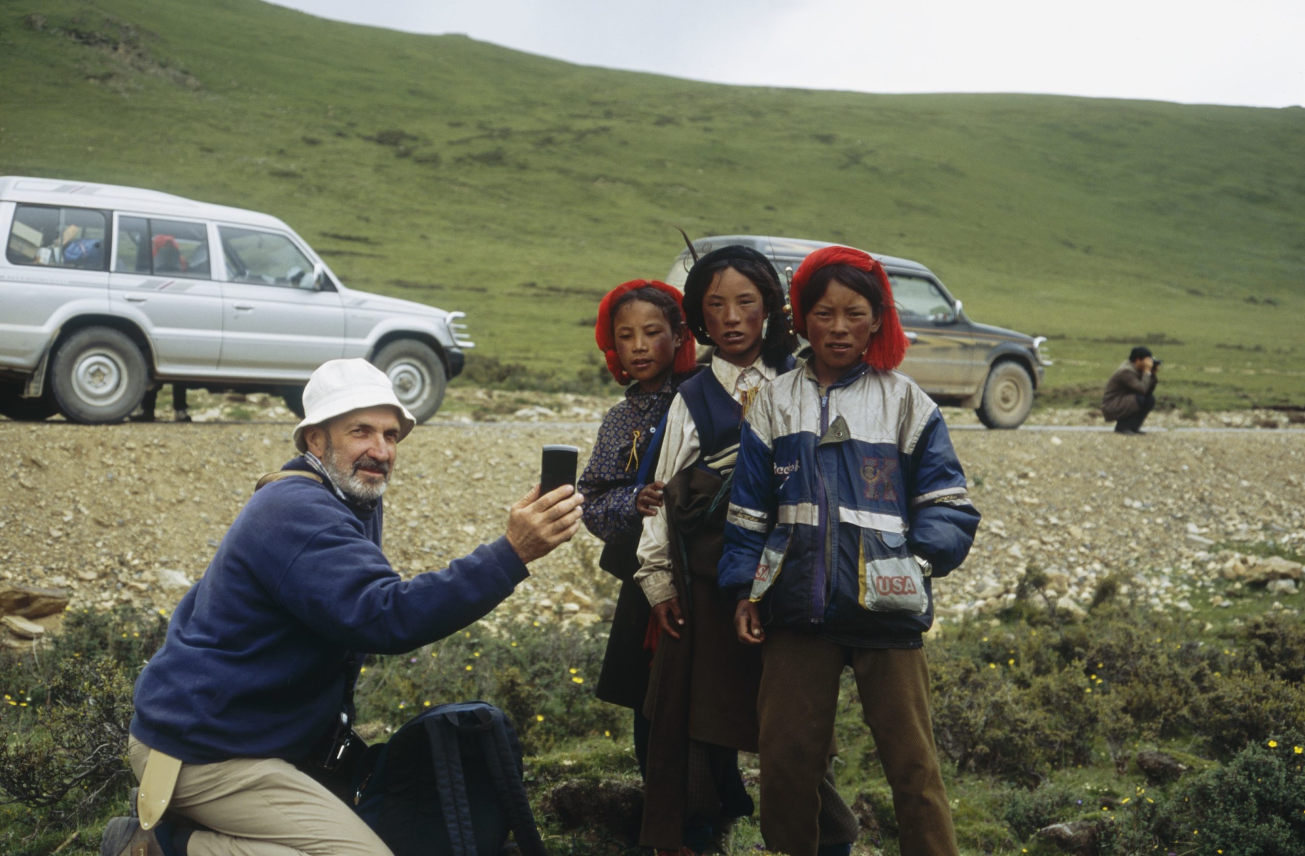 David Boufford and three Tibetan children in a grazed meadow with scrub Rhododendron along Highway 214 from Bangda (Bamda) to Qamdo, Tibet.