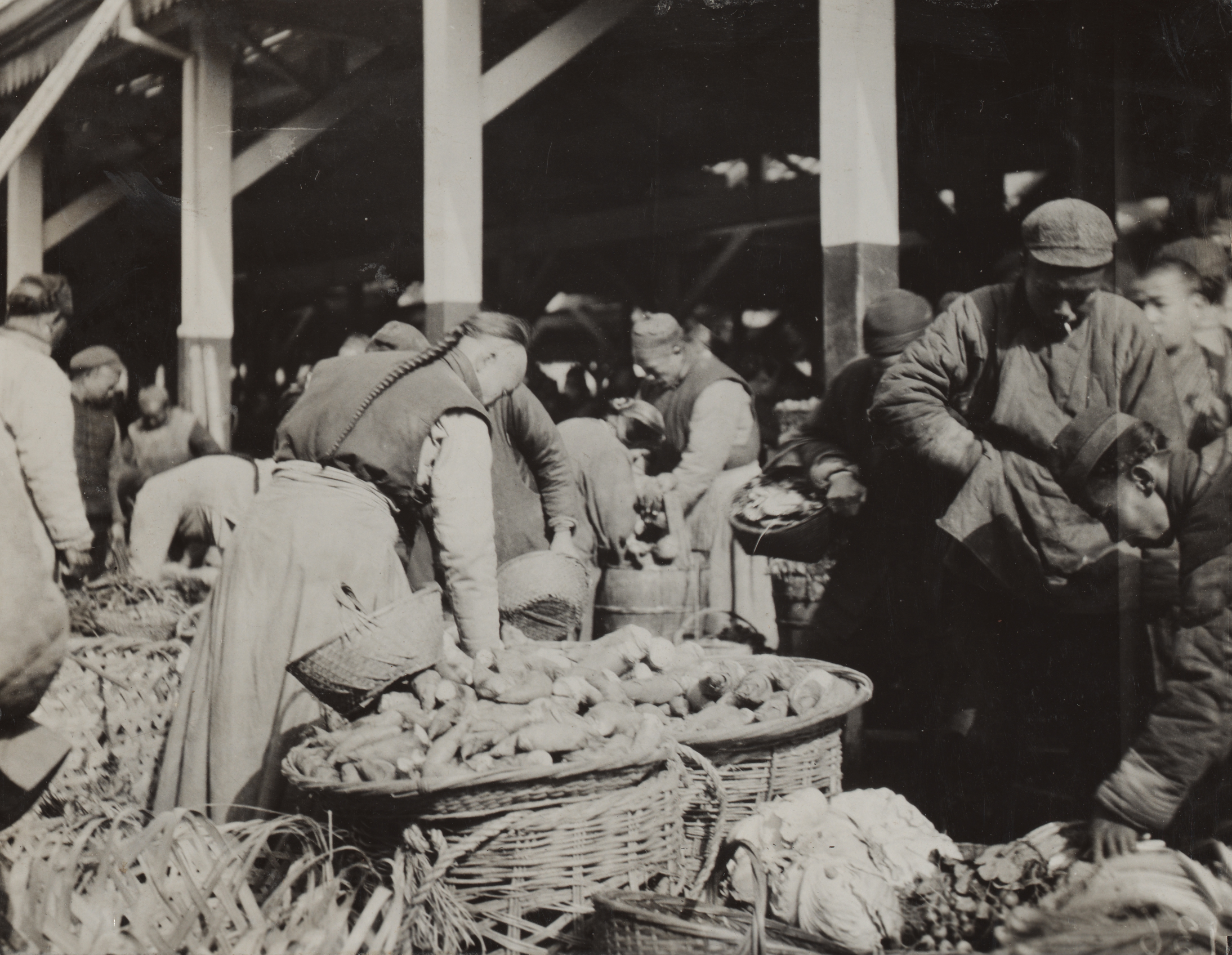 A scene from the Hongkew public market, Shanghai with baskets of bamboo shoots.