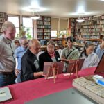 A women shows a group of adults a display in a library