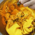 Fabric and plants in a yellow dye bath