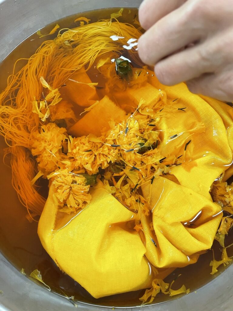 Fabric and flowers in a yellow dye pot