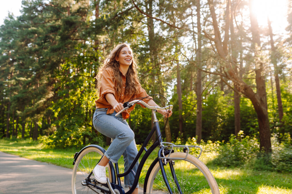 Woman rides a bike on a forested path