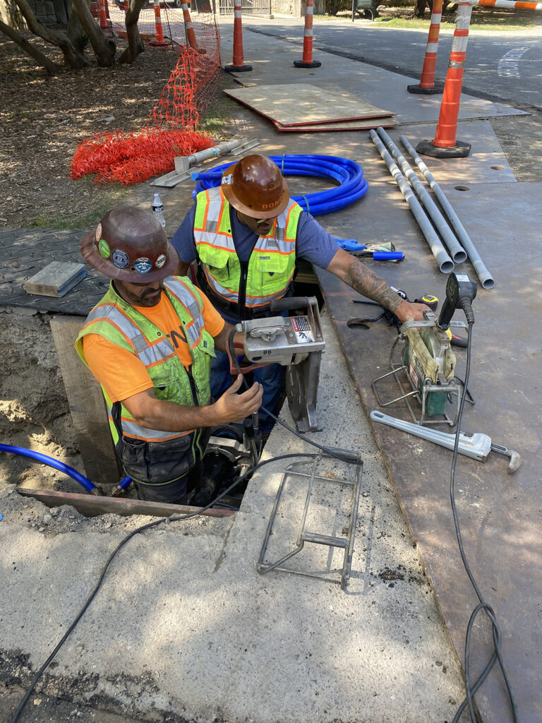 The project contractor using heat fusion equipment to fuse new irrigation pipes at Flora Way Gate
