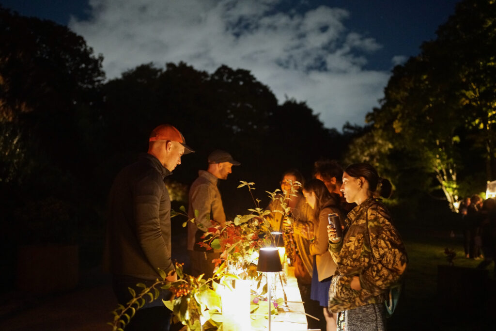 People enjoying drinks at a table with plants