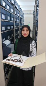 Syahida Emiza holding a herbarium specimen
