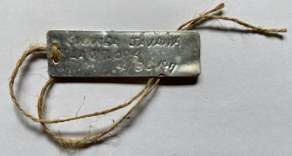 metal tag for Kanga javana with twine cord against a blank background