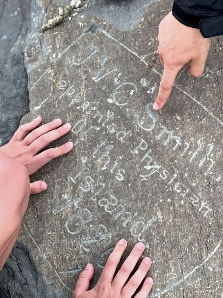 hands touching an engraved stone